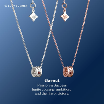 Two necklaces with garnet stones on a blue background, featuring the brand 'Lucy Summer'.